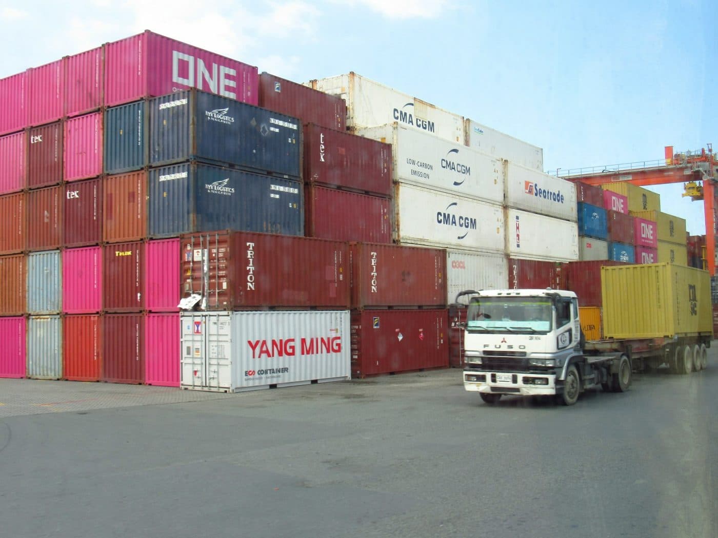 Stacked shipping containers and truck at a logistics port